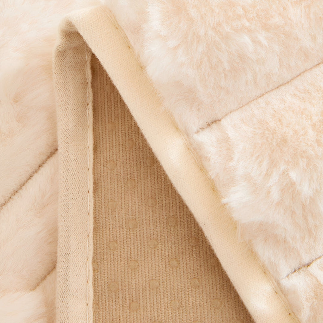 Envers de la housse retourné, montrant la doublure beige tricotée parsemée de petits points antidérapants et la couture du bord. 6