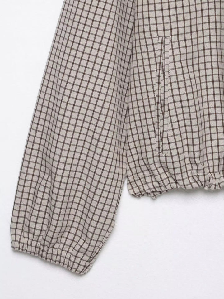 Détail à plat d'une manche à poignet élastique et de la poche latérale, avec le bas de la veste froncé. 8