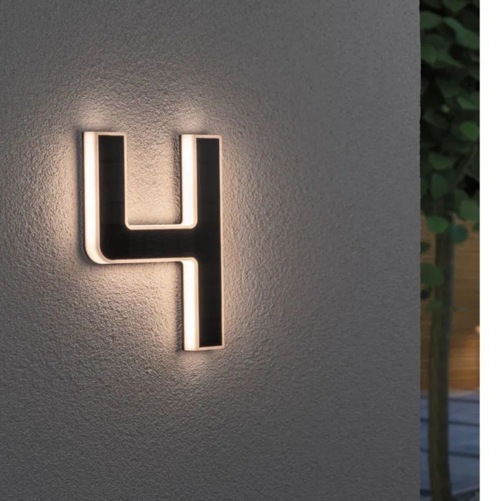 Chiffre 4 lumineux posé sur un mur crépi, face solaire noire et lumière blanc chaud sur les bords. 5