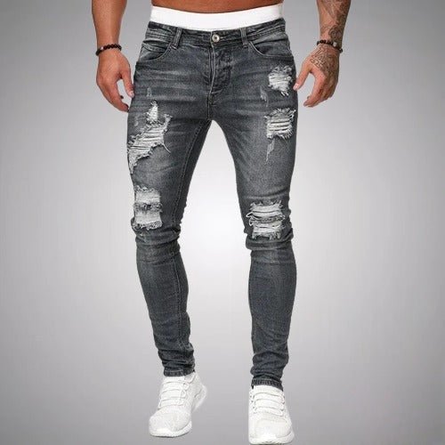 Jean slim déchiré gris anthracite délavé porté de face par un homme en baskets blanches, avec déchirures aux cuisses et genoux. 5