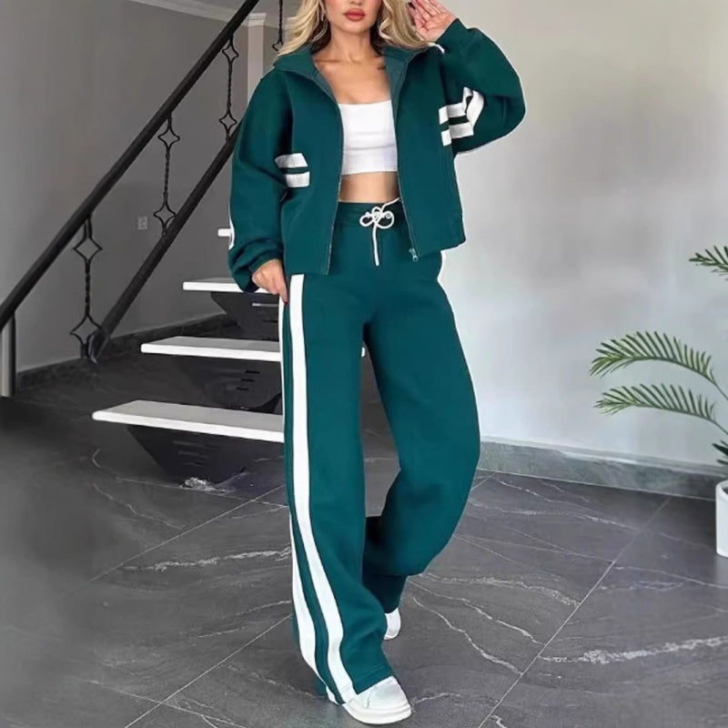 Femme en ensemble vert foncé à bandes blanches, veste zippée courte et pantalon large à cordon de serrage blanc. 5