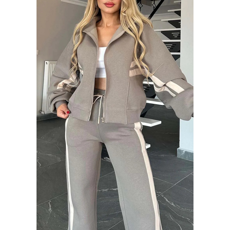 Détail de la veste zippée grise à bandes beiges sur les manches, avec poches et cordon de taille du pantalon. 7