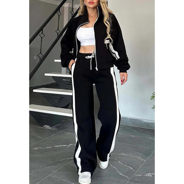 Ensemble noir à bandes blanches porté avec un haut court blanc, veste zippée entrouverte et cordon de taille visible. 4