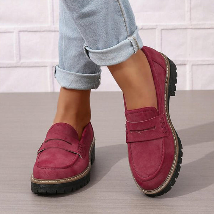 Mocassins bordeaux portés avec un jean clair retroussé, vus de face et de profil sur fond de mur blanc. 4