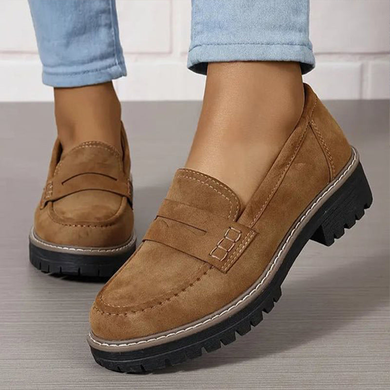 Gros plan sur des mocassins marron portés avec un jean bleu, détail des surpiqûres et de la semelle crantée. 5