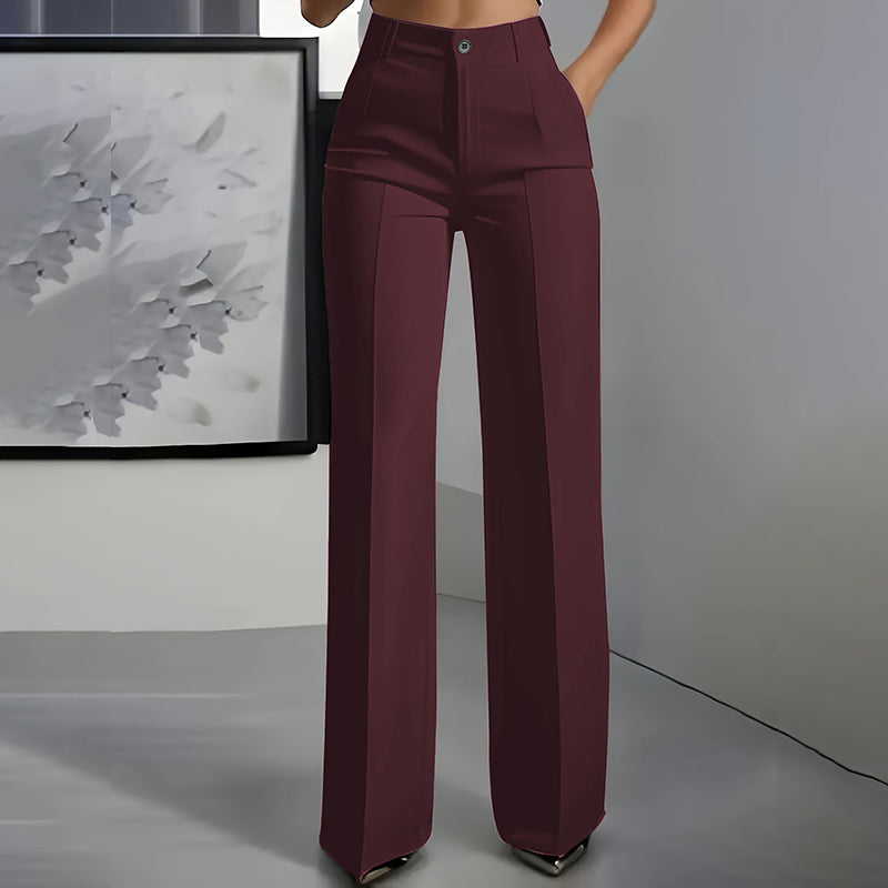 Vue de face du pantalon en bordeaux, taille haute, jambe droite et pli sur le devant, devant un décor gris. 4