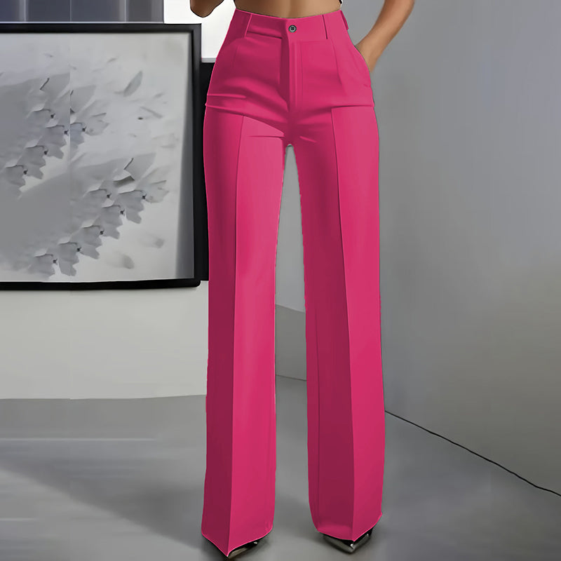 Vue de face du pantalon rose vif taille haute, jambe droite et pli marqué, une main dans la poche. 7