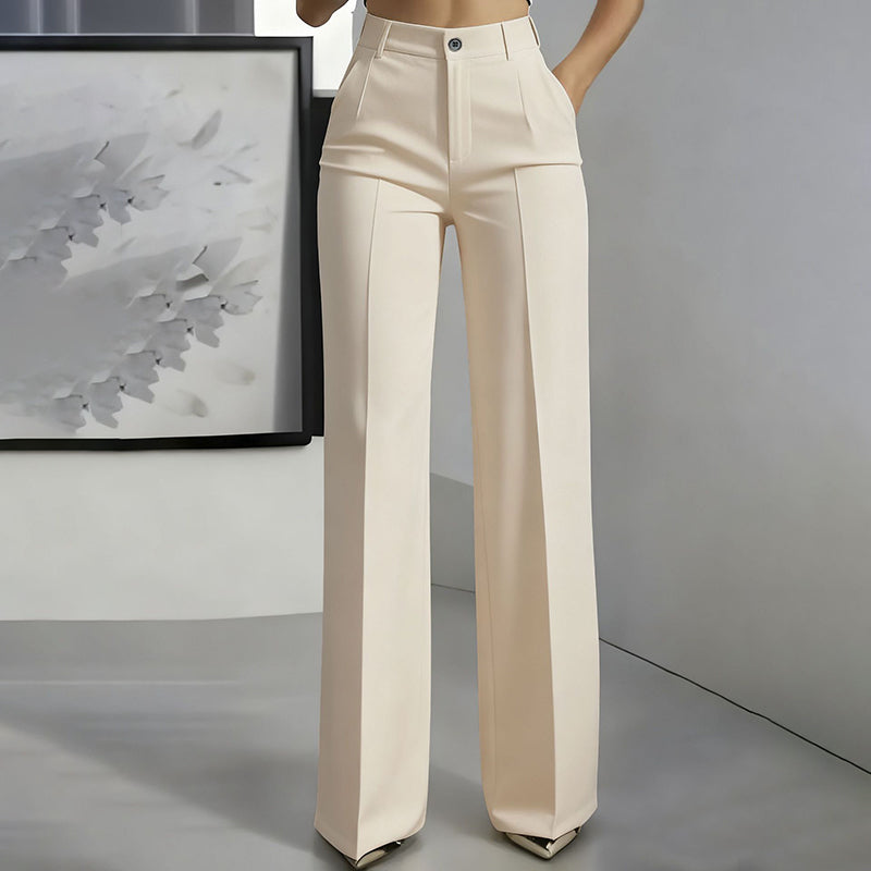 Vue de face du pantalon beige clair taille haute, jambe droite et pli marqué, une main dans la poche. 5