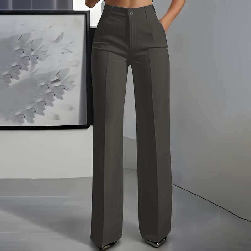 Vue de face du pantalon gris anthracite, taille haute, jambe droite avec pli, porté devant un tableau clair. 6