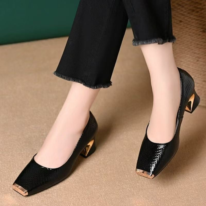 Escarpins noirs vernis portés avec un pantalon noir effiloché, vus de face, avec bout carré doré et talon sculpté. 1