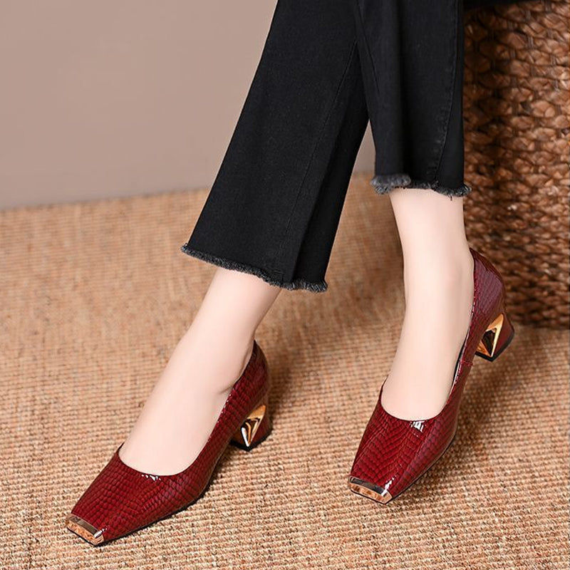 Escarpins bordeaux vernis à effet écailles portés par un modèle, avec pantalon noir et bout carré à embout métallique doré. 2