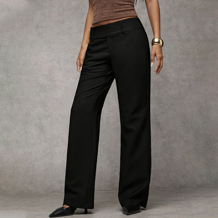 Pantalon noir porté en vue de trois quarts, jambes droites et larges, ceinture plate boutonnée sur le côté. 2