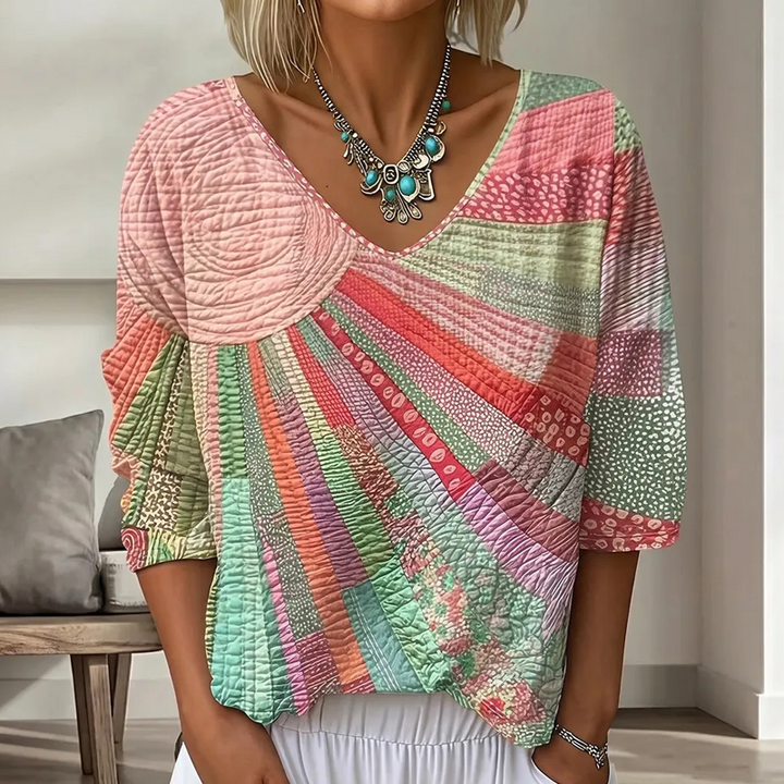 Blouse à col en V en version rose, vert menthe et corail, portée avec un collier, motif de soleil et rayons en patchwork. 3