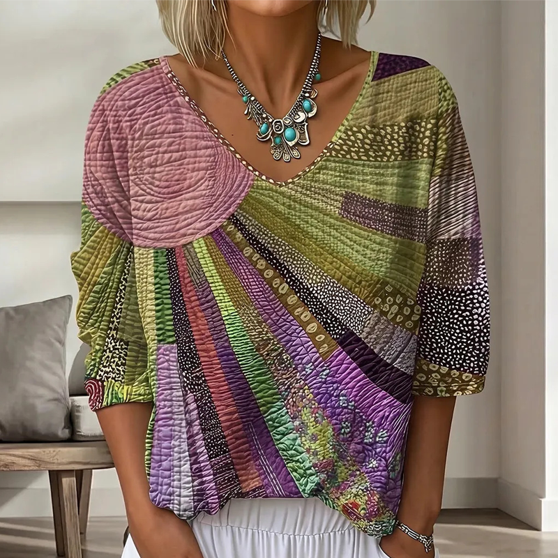 Version vert olive, violet et rose de la blouse patchwork à col en V, portée avec un collier orné de pierres turquoise. 4