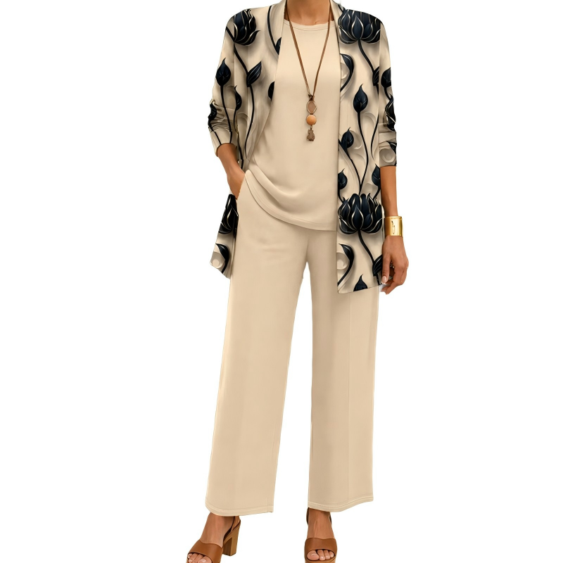 Ensemble beige porté par un mannequin, cardigan long à grandes fleurs sombres, haut uni, pantalon large et collier à pendentif. 1