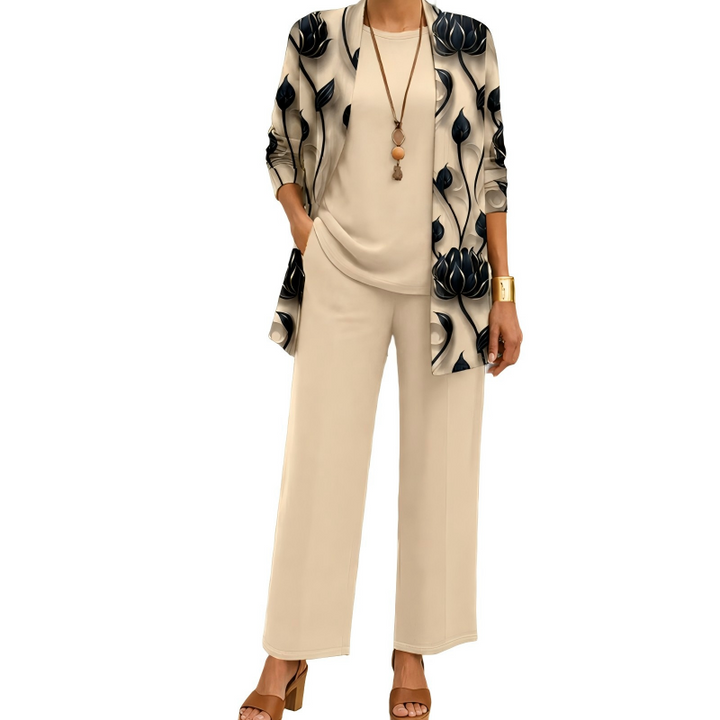 Ensemble beige porté par un mannequin, cardigan long à grandes fleurs sombres, haut uni, pantalon large et collier à pendentif. 1