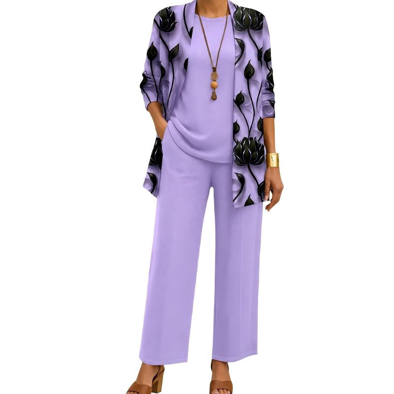 Ensemble lilas porté de face, cardigan long à fleurs noires, haut uni, pantalon ample et collier à pendentif en bois. 4