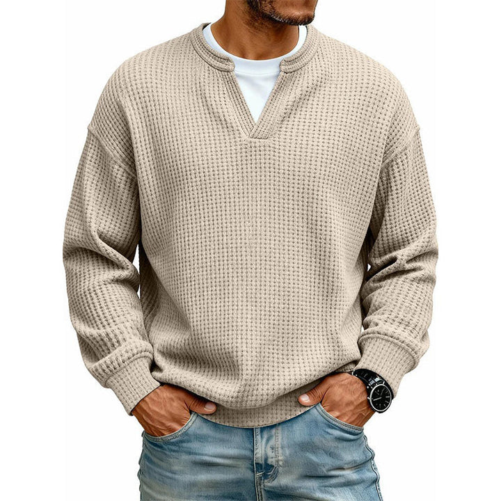 Haut en maille gaufrée beige sable, encolure en V sur t-shirt blanc, porté par un modèle en jean, vue de face. 11
