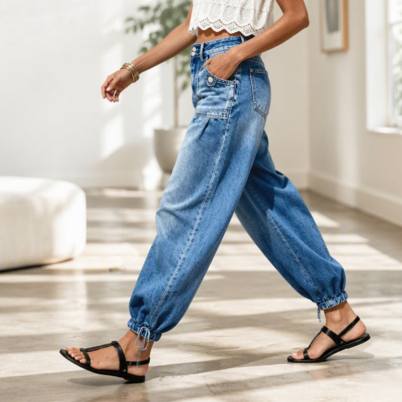Femme en marche vue de profil, jean barrel bleu à jambes bouffantes, lien noué à la cheville, dans un intérieur lumineux. 7