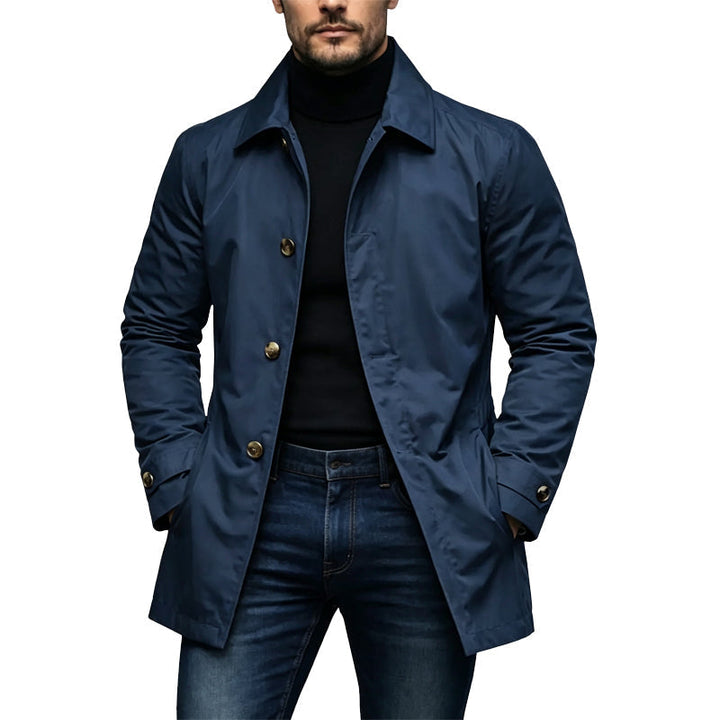 Homme portant le trench bleu marine aux boutons dorés, avec col roulé noir et jean 3