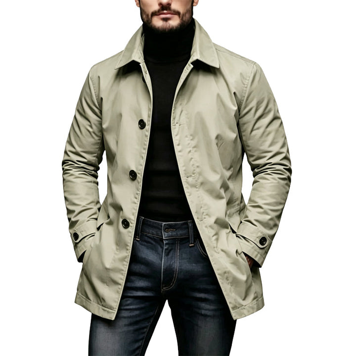 Version beige clair du trench portée par un homme, avec col roulant noir et jean bleu foncé, poignets à patte boutonnée. 3