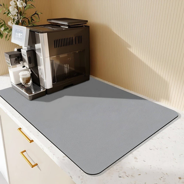 Grand tapis gris clair uni sur un plan de travail moucheté, avec une machine à café noire et argent. 8