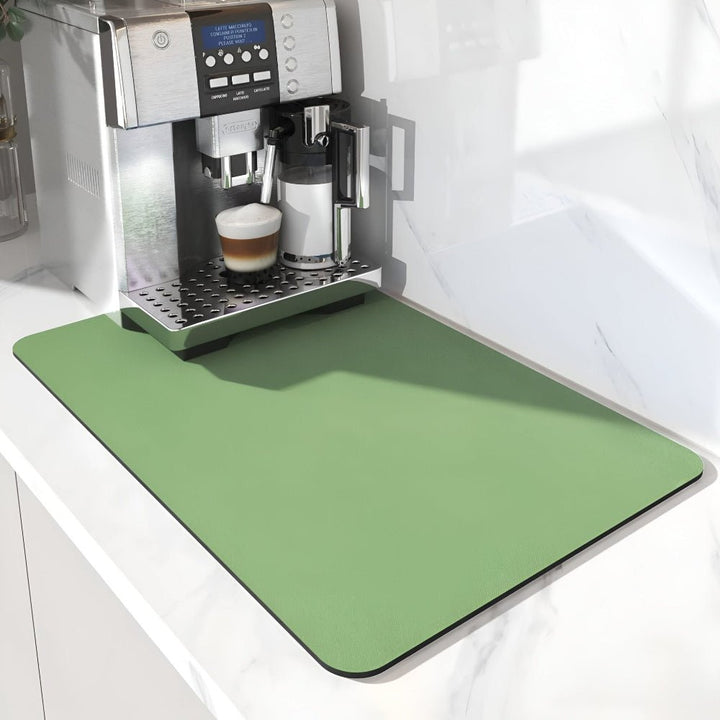 Tapis vert sauge uni sous une machine à café et son pot à lait, sur un plan de travail en marbre. 6
