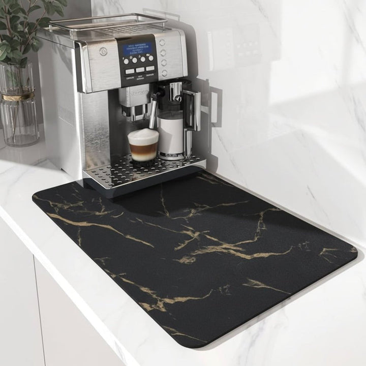 Tapis noir veiné de doré façon marbre, posé sous une machine à café sur un plan de travail blanc. 5