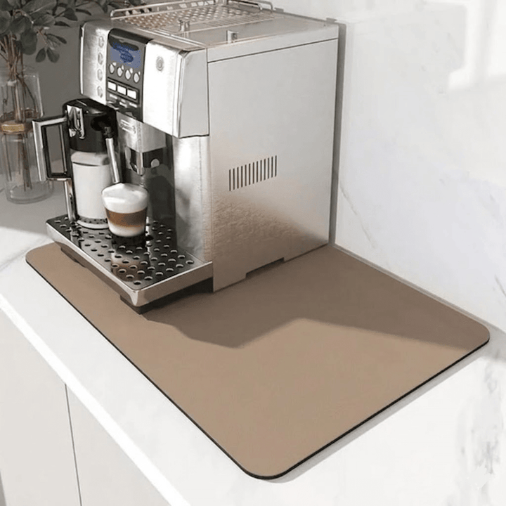 Tapis beige sable uni sous une machine à café en inox, avec un cappuccino en cours de préparation. 7