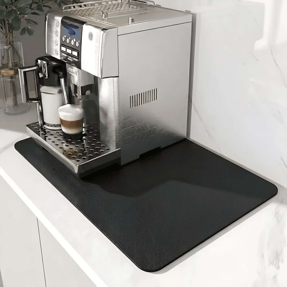 Tapis noir uni à surface légèrement texturée sous une machine à café, sur un plan de travail en marbre blanc. 9