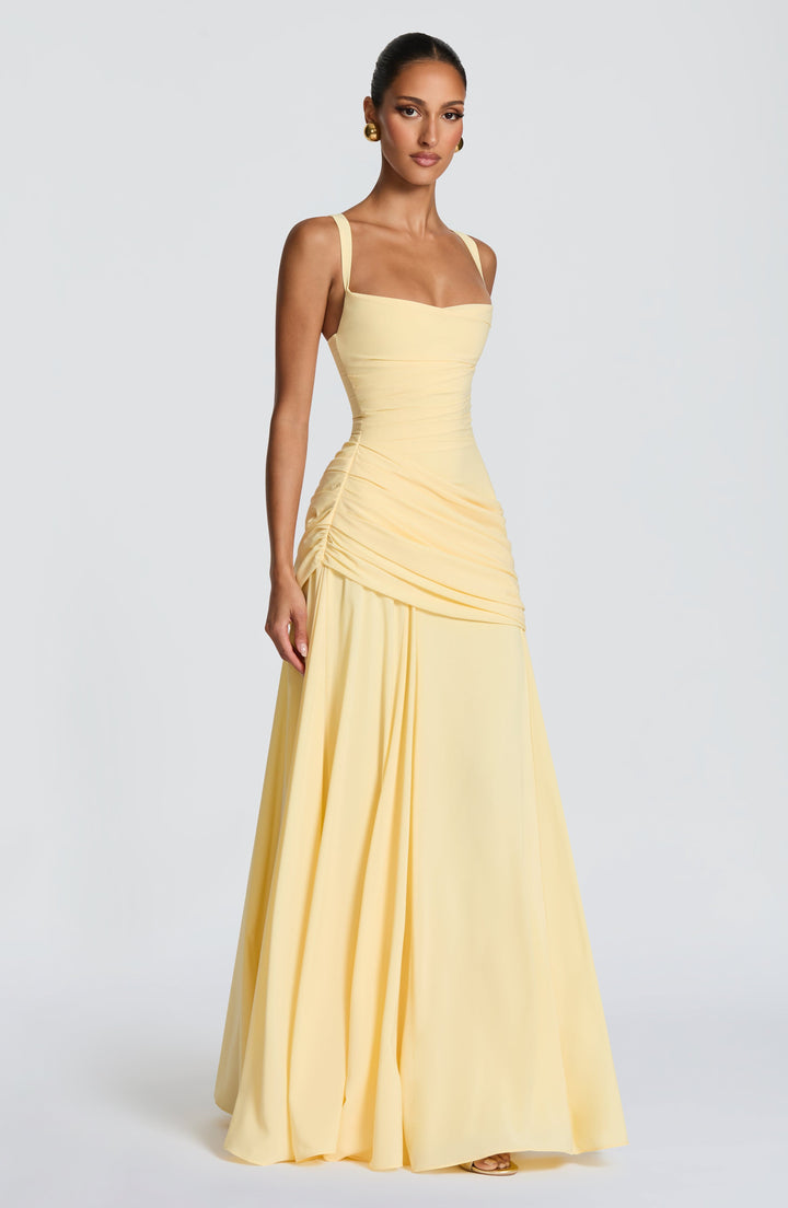 Robe longue jaune pâle portée de trois quarts, avec encolure carrée, taille ajustée et ample jupe fluide. 3