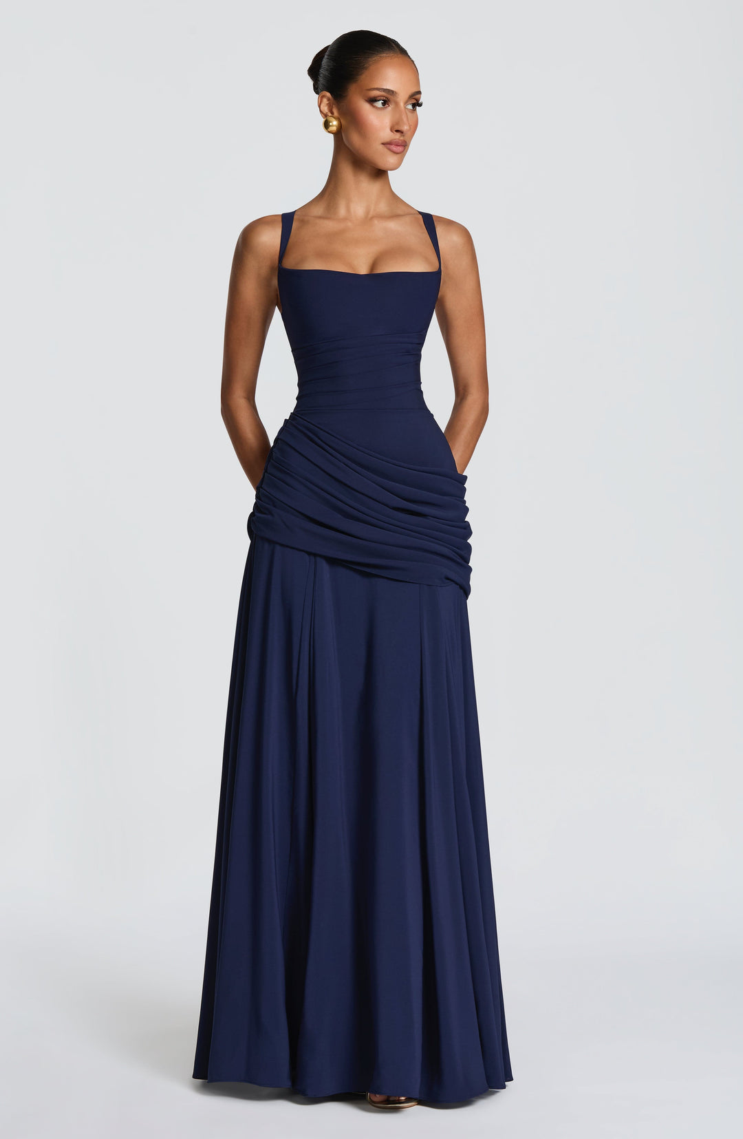 Robe bleu marine portée de face, mains dans les poches, avec corsage ajusté, drapé sur la hanche et jupe évasée. 8