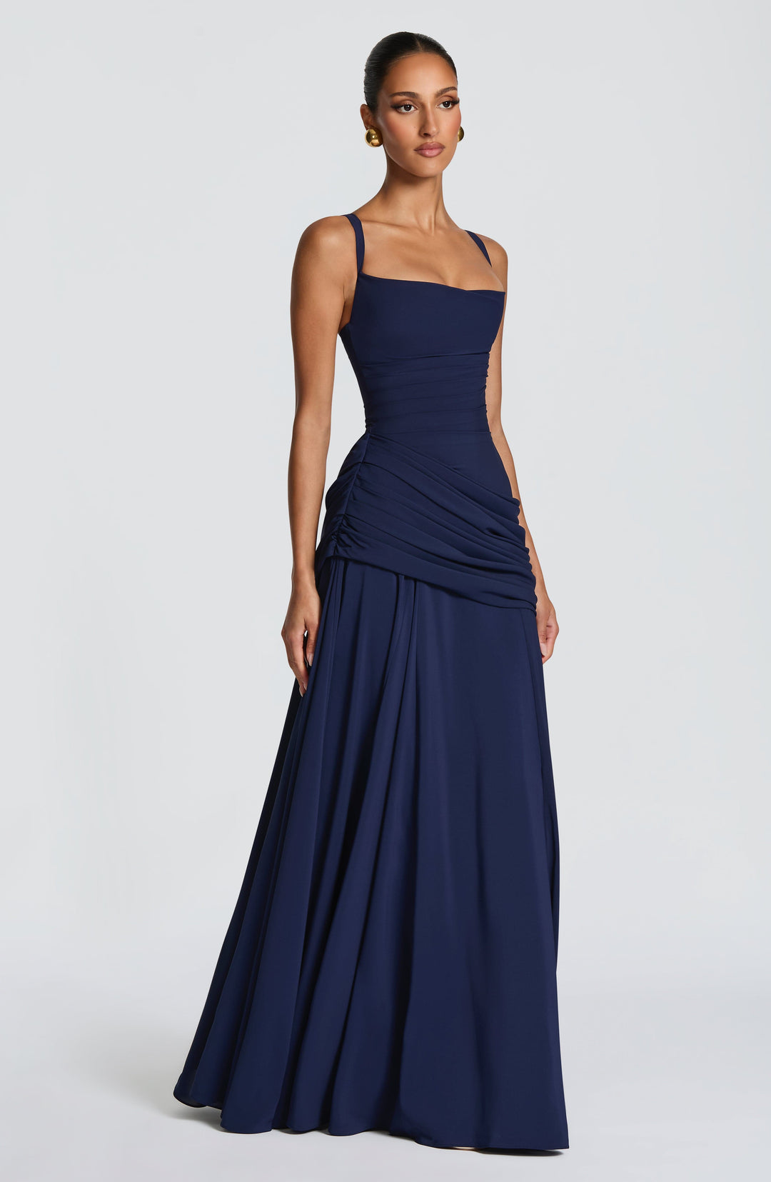Robe bleu marine vue de trois quarts, bretelles fines, froncé latéral à la taille et jupe ample qui tombe jusqu'au sol. 10