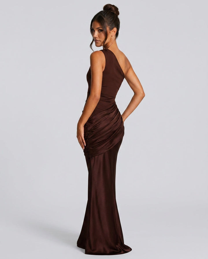 Vue de dos en trois-quarts de la robe marron, mannequin au chignon, plis drapés sur la hanche et bas évasé. 7