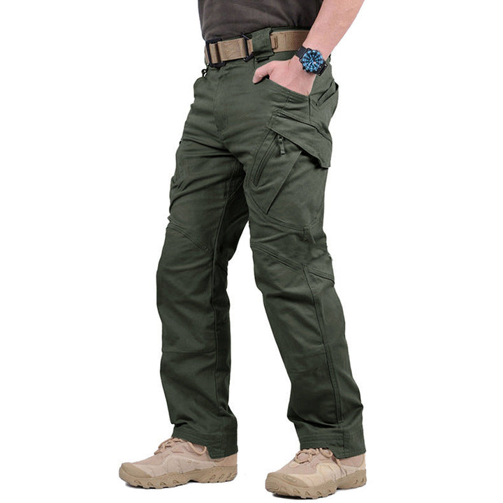 Pantalon vert kaki porté de trois quarts avec ceinture beige, montre bleue et chaussures de randonnée 4