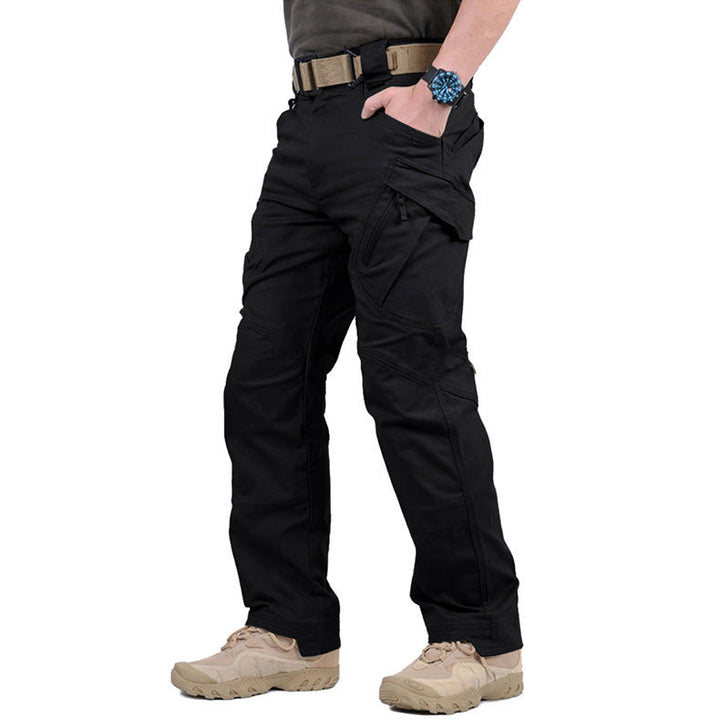 Pantalon noir porté de trois quarts avec ceinture beige, main dans la poche, poche cargo zippée visible 5