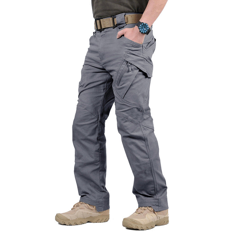 Pantalon gris porté de trois quarts avec ceinture beige, main dans la poche, poche cargo zippée visible 6