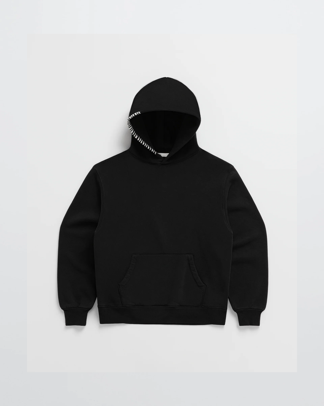 Sweat à capuche noir posé à plat, poche kangourou et couture blanche en zigzag sur le bord de la capuche. 5