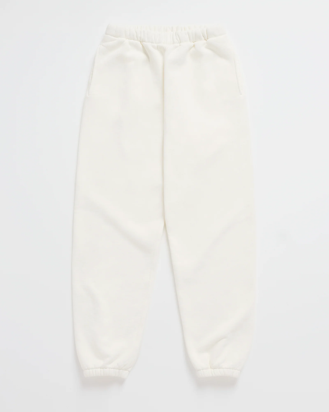 Pantalon de jogging blanc cassé posé à plat, ceinture élastique, poches latérales et bas de jambes resserrés par un élastique. 7