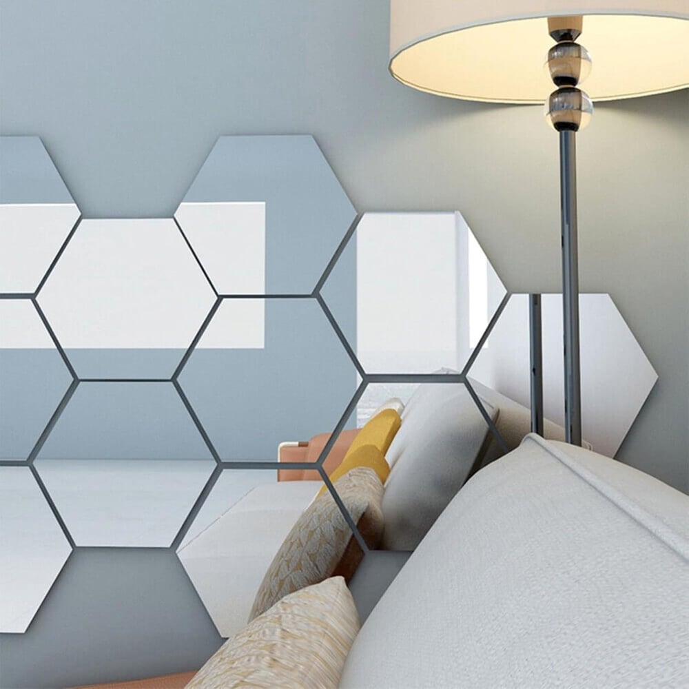 Hexagones de miroir collés au mur d'un salon, reflétant un canapé aux coussins beiges et jaunes, près d'un lampadaire. 6