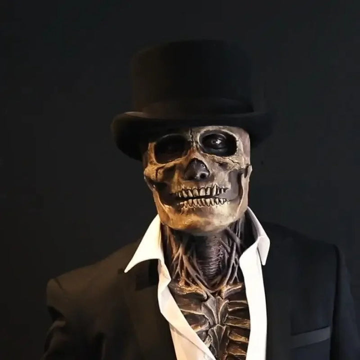 Personne portant le masque de crâne réaliste avec haut-de-forme noir, veste sombre et chemise blanche, vue de face sur fond noir. 1