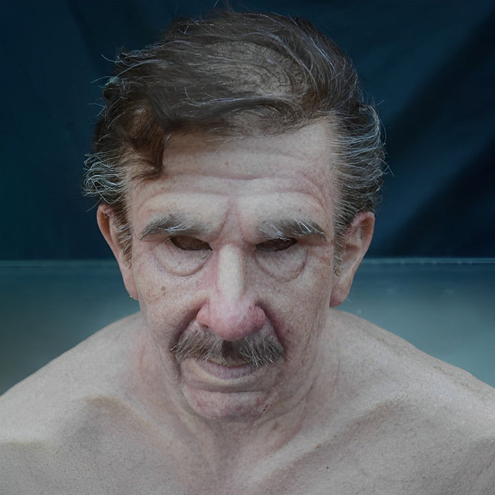 Masque de vieil homme aux cheveux bruns et gris, sourcils blancs, poches sous les yeux et moustache, buste moulé visible. 14