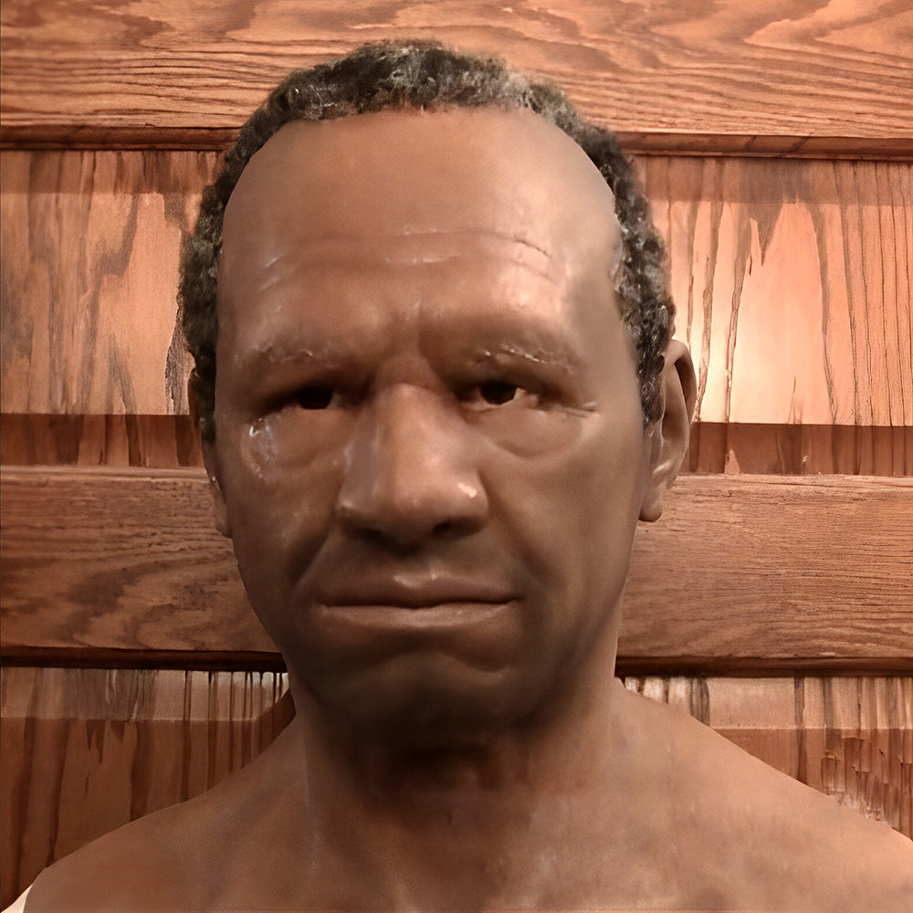Masque réaliste de visage d'homme à la peau brune, cheveux courts grisonnants, vu de face devant un mur en bois. 23