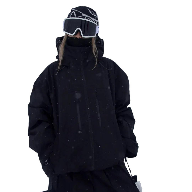 Veste noire portée par un modèle avec bonnet et masque de ski, vue de face, col montant et poches zippées discrètes. 3