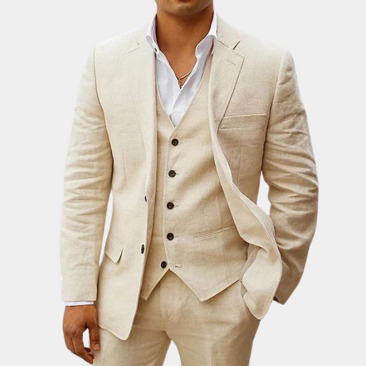 Costume trois pièces beige clair porté par un homme, veste à revers cranté ouverte sur gilet boutonné et chemise blanche. 1