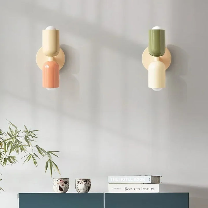Deux appliques côte à côte, l'une crème et corail, l'autre vert olive et crème, au-dessus d'un meuble bleu-vert. 14