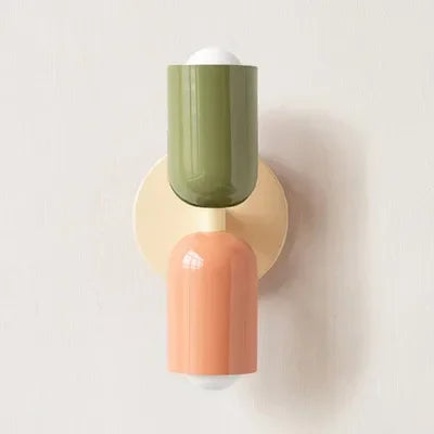 Applique à tête vert olive et corps corail, avec platine crème, vue de face sur mur clair. 19