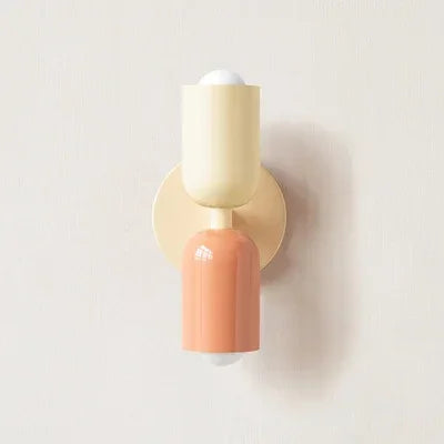 Applique à tête crème et corps corail, avec platine crème, vue de face sur mur clair. 16