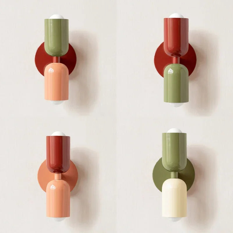 Quatre versions de l'applique côte à côte, associant vert, rouge, corail et crème sur fond mural clair. 12
