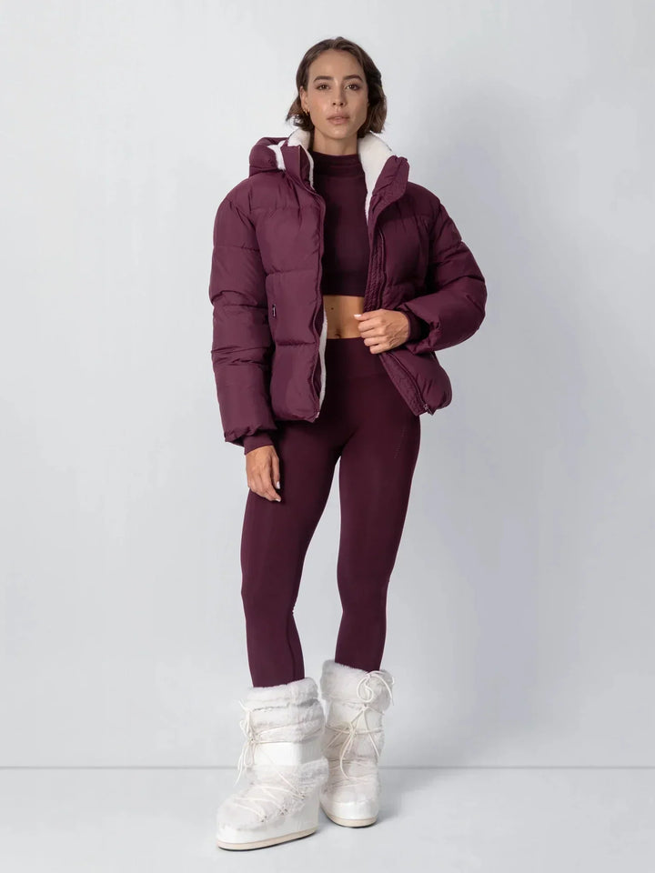 Mannequin en pied portant la veste prune ouverte, ensemble assorti et bottes fourrées blanches 17